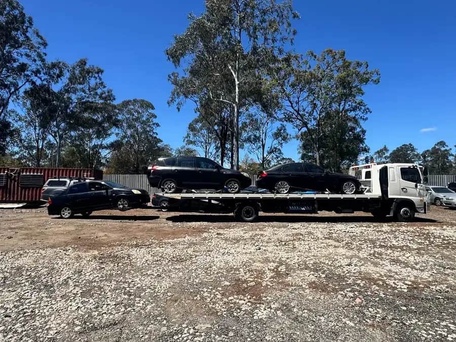 Side view of the A1 tow truck loaded with two cars in the yard